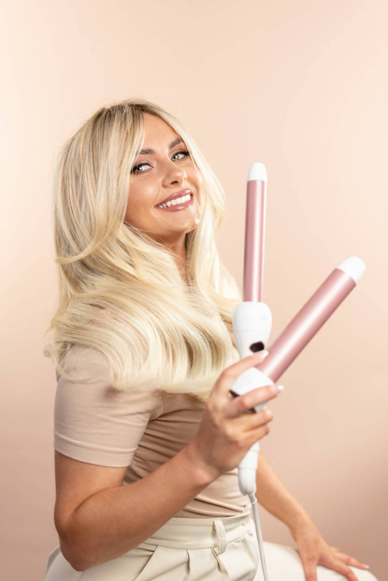 A photo of BY CiNCO owner Kendall Drake with her heat styling wand product