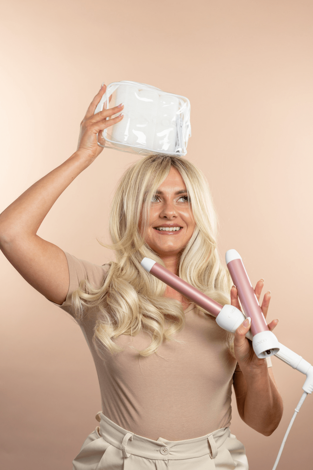 A photo of Cinco Hair Boutique owner holding the styling wand and rollers